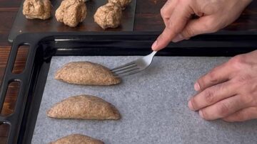 Ένα πηρούνι πατάει την άκρη από το τυροπιτάκι.